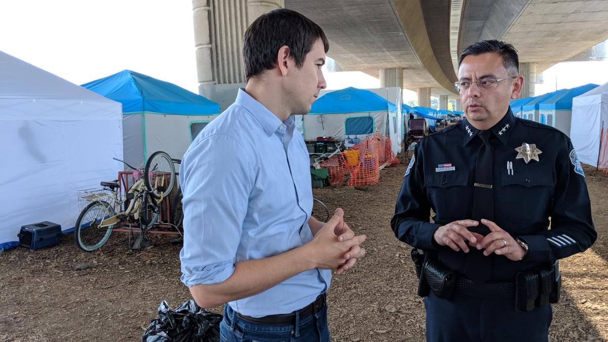 Rep. Harder in front of a row of tents